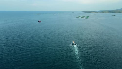 Service Boat Cruising to Aquaculture Fish Farm in Sea