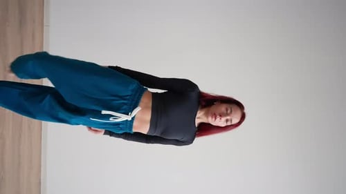 Athletic Woman with a Steep Stretch in Sportswear Performs Splits While Standing