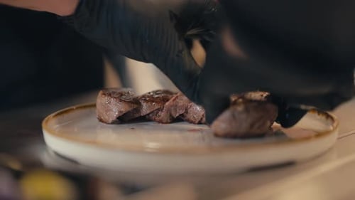 Chef serving delicious cooked meat on plate, close up view