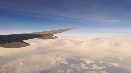 Aile d'avion sous une grande formation nuageuse au-dessus de l'océan pendant le vol, conditions météorologiques dramatiques et