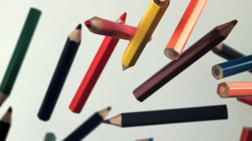 Multicolored Pencils Fly Up and Fall on a White Background Filmed on a Highspeed Camera at 1000 Fps