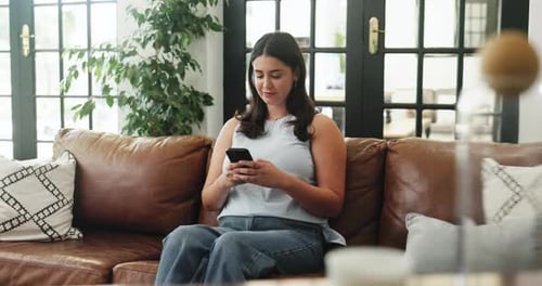 Woman Using Mobile Phone While Sitting on Couch