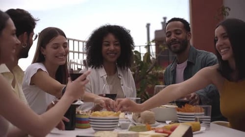 Celebration of a Group of Friends Gathered at a Table on a Rooftop Terrace Sharing and Having Fun
