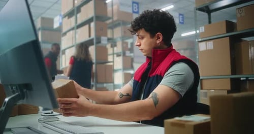 Slow Motion of Inventory Manager Scanning Parcel Preparing for Shipping Working on Computer