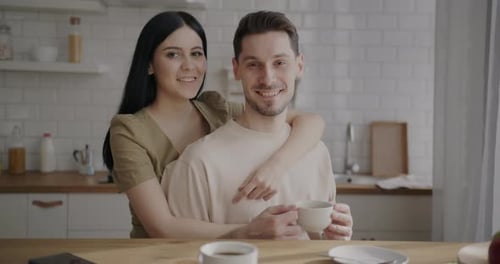 Affectionate Couple Smiling Together in a Bright Kitchen