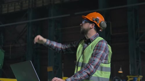 Male Worker Manages the Work of Industrial Equipment and Uses Laptop