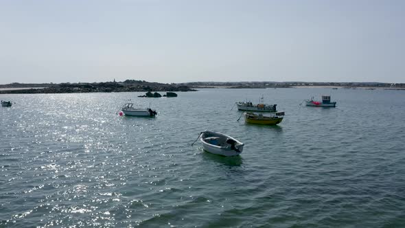 Low drone footage over small fishing boats in peaceful bay at anchor ...