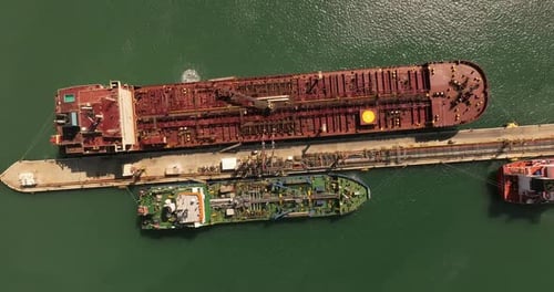 Oil tankers unloading crude oil in a port terminal.