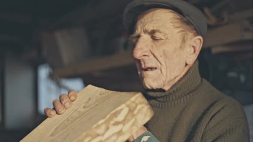 Senior Carpenter Checking Sanded Plank in His Workshop