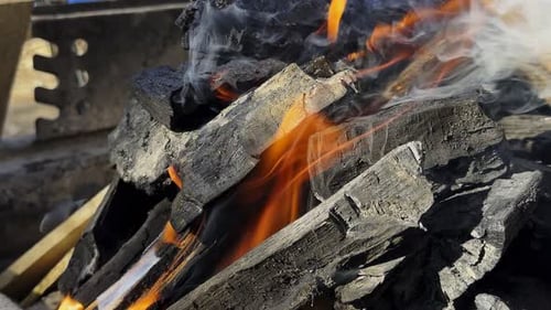 Burning Charcoal Ignites with Orange Flames and Smoke