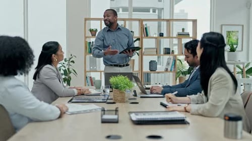 Diverse Business Team Listens to Presentation in Office