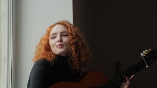 Woman Plays Guitar by Window