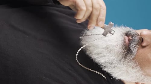 Adult Holding Silver Cross on Silver Chain