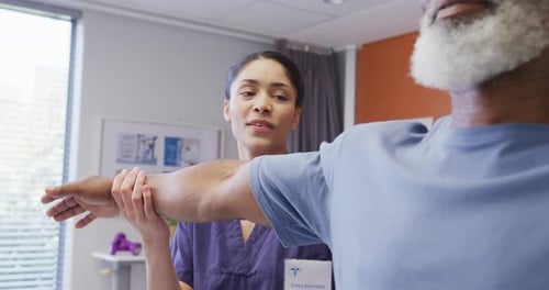 Physical Therapist Assisting Senior with Arm Extension