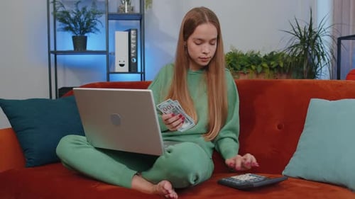 Smiling Happy Girl Counting Money Cash and Use Laptop Pc Calculate Domestic Income Earnings at Home