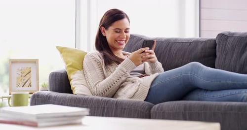 Woman, laugh and relax with phone on sofa, reading funny social network post