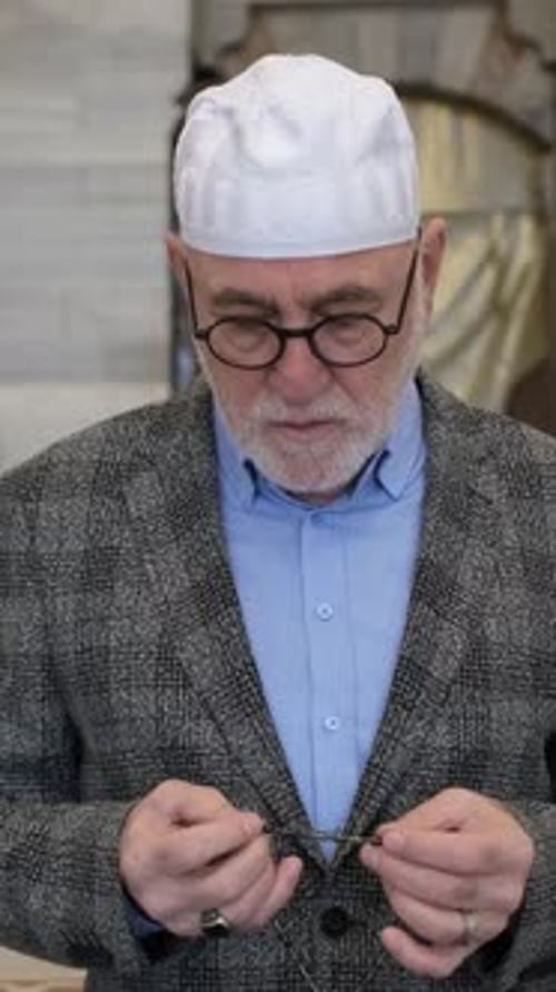 Man in Cap Holding Prayer Beads