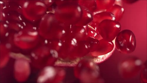 Pomegranate Grains Rolls Down on Surface of Broken Pomegranate in Slow Motion