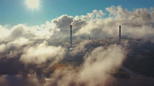 Power plant smokes. Aerial view of the power plant with smoking pipes and clouds passing by