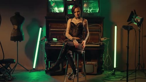 Sexy Lady in Black Clothes Posing on Chair in Studio Slender Tattooed Body Alternative Fashion and