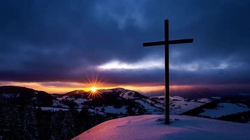 Cross Silhouette Against Mountains at Dramatic Winter Sunrise