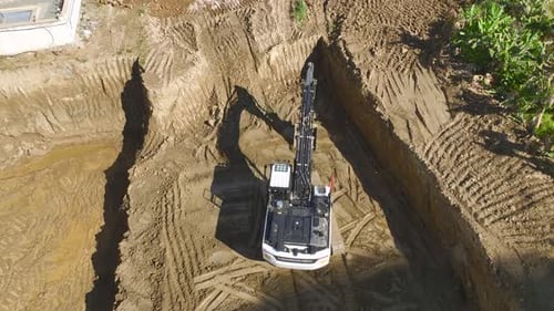 Excavator Digging Trench on Construction Site Aerial View