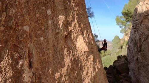 Man rock climbing aerial view of sportsman rapelling mountain in La Panocha, el Valle Murcia, Spain