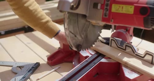 Adult Cutting Wood with Miter Saw