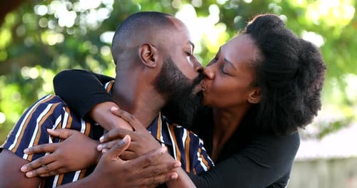 Affectionate Couple Embracing and Kissing Outdoors in Natural Light