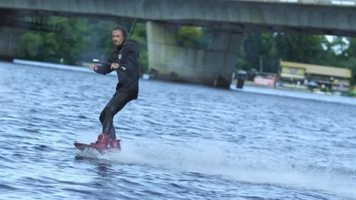 Energy Sportsman in Black Swimsuit Wakeboarding. Extreme Summertime on River. Wakeboarder Surfing