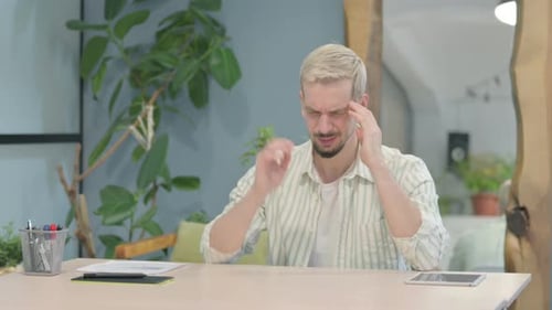 Man Experiencing a Headache at his Desk