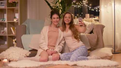 Two Women Taking Selfie At Home at Night