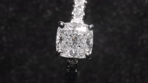 Top down, expensive diamond engagement ring rotating against black background