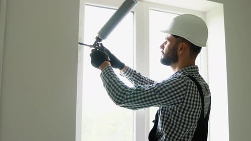 Construction Worker Installing Window with Foam Gun