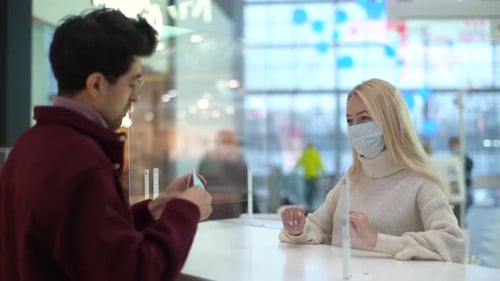 Woman and Man at Reception Wearing Surgical Masks