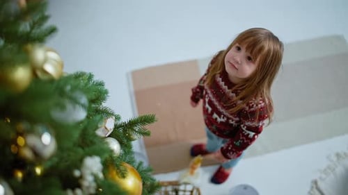 Young Girl Decorating Christmas Tree at Home