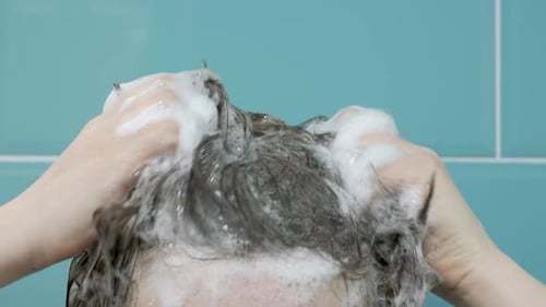 Person Washing Hair with Shampoo in Shower