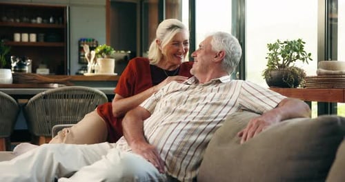 Senior couple, talk and laugh on sofa for bonding, love and care with funny story in lounge