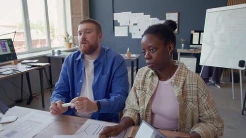 Smiling Black Female UI Designer Discussing Ideas with Colleagues at Office