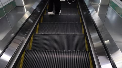 person standing on an escalator from a high angle perspective
