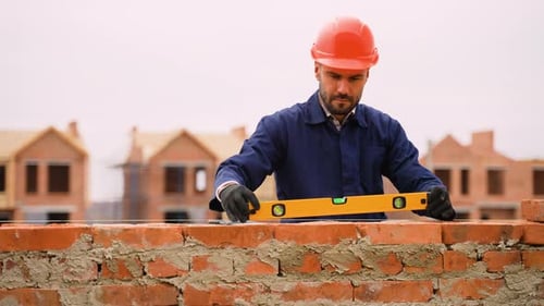 Maurer überprüft Wandausrichtung auf der Baustelle