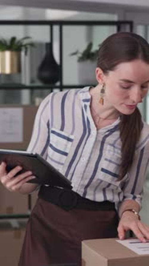 Woman Using Tablet in Workplace Near Box
