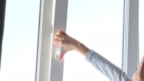 Woman Opens Window for Fresh Air and Daylight