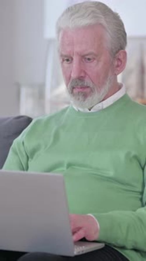 Senior Man Working on Laptop Computer at Home