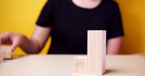 Hand putting wood cube on top of wood block stacking as step stair.business growth to success and pl