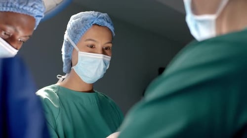 Diverse weibliche und männliche Chirurgen in Masken, Übergeben chirurgischer Instrumente während der Operation, Zeitlupe