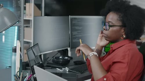 Black Female Office Employee Looking at Program Codes on Laptop Screen