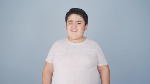 Child Making Faces Against Light Blue Background