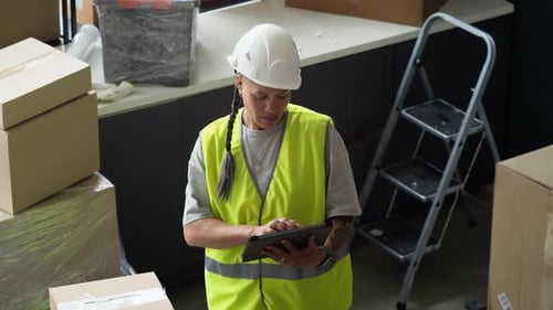 Woman Warehouse Worker Checking Inventory on Digital Tablet