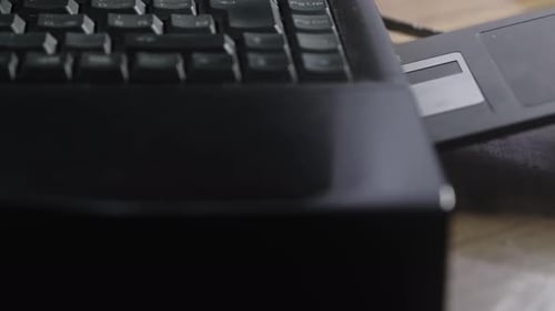 Computer user inserts outdated floppy disc data storage into laptop